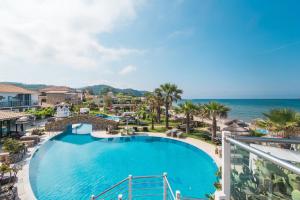 a view of the pool and ocean from the balcony of a resort at Mirage Arillas Studio Type A1 in Arillas