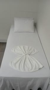 a white bed with a pillow on top of it at Hotel AG3 in Teixeira de Freitas +16 photos