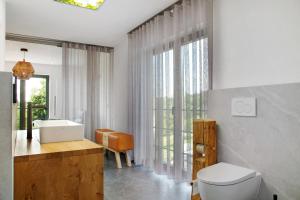 a bathroom with a toilet and a sink and a window at Chalet Sonnenwald in Grattersdorf +29 photos
