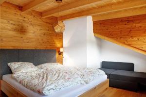 a bed in a room with a wooden ceiling at Chalet Sonnenwald in Grattersdorf