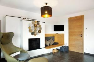 a living room with a fireplace and a chair at Chalet Sonnenwald in Grattersdorf