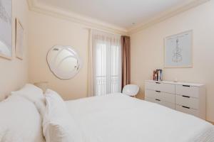 a white bedroom with a white bed and a dresser at Porto Montenegro Luxury Experience in Tivat