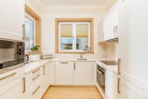 a white kitchen with a sink and a microwave at Porto Montenegro Luxury Experience in Tivat