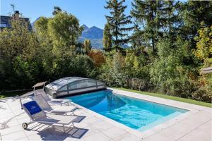 a swimming pool with two lounge chairs and a glass house at Laltizoard in Briançon