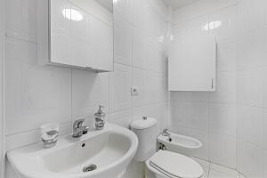 a white bathroom with a sink and a toilet at Apartamento El Tute in Bajamar +13 photos