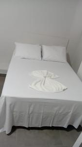 a white bed with white sheets and pillows at Hotel AG3 in Teixeira de Freitas