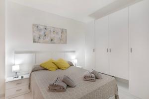 a white bedroom with a bed with two pillows on it at Apartamento El Tute in Bajamar