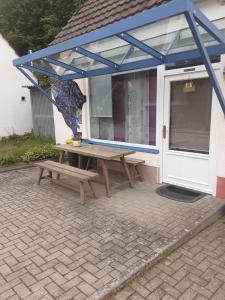 a picnic table and bench in front of a house at Garten der Ruhe in Osterbuch