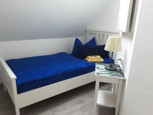 a bedroom with a bed with blue sheets and a table at Garten der Ruhe in Osterbuch