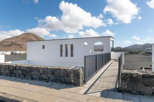a white building with a stone wall at Marde Loft in Tinguatón