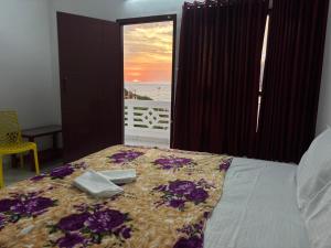 a bedroom with a bed with a view of the ocean at Udaya Hotel in Kovalam +52 photos