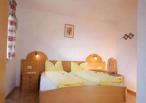 a bedroom with a bed with yellow pillows at Lechnerhof Appartement Alpenrose in Schenna +98 photos