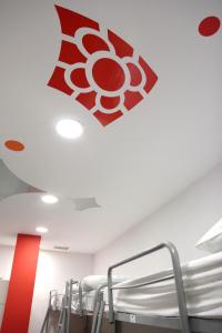 pokój z czerwono-białym znakiem na suficie w obiekcie Botxo Gallery - Youth Hostel Bilbao w mieście Bilbao
