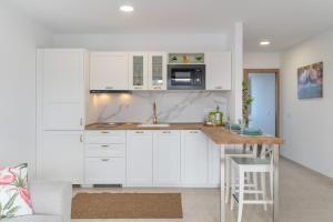 a kitchen with white cabinets and a counter top at Marde Loft in Tinguatón