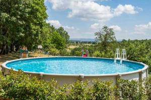 a large swimming pool in a yard with trees at Faetino - Gallo in Colle di Val d'Elsa