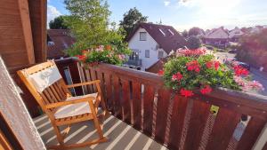 a rocking chair on a balcony with flowers at Ferienglück Goldach in Hallbergmoos