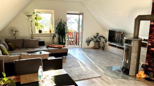a living room with a couch and a fireplace at Ferienglück Goldach in Hallbergmoos +4 photos