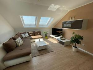 a living room with a couch and a flat screen tv at Hegaublick in Stockach