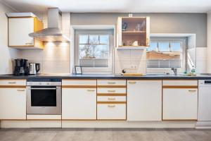 a kitchen with white cabinets and blue counter tops at Fewo Heimathafen in Osterbruch