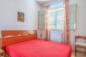 a bedroom with a red bed and a window at Casa Nico in Augusta