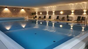 a large swimming pool with blue lighting in a building at Rhön Residence in Dipperz