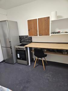 a kitchen with a wooden table and a refrigerator at Maison ouvrière pour 10 personnes in Trignac