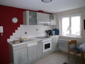 a kitchen with white cabinets and a sink and a window at Gästehaus Fischerhäusle in Mitten