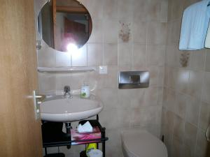 a bathroom with a sink and a toilet and a mirror at Gästehaus Fischerhäusle in Mitten +31 photos