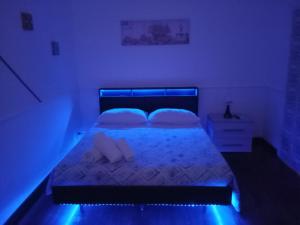 a bedroom with a bed with blue lights on it at I 4 mori in Fiumicino