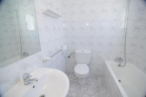 a white bathroom with a toilet and a sink at Hostal Rosalia in San Antonio