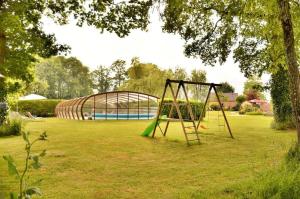 a swing set in a yard with a pool at Domaine de Lestroué - Île d'arz in La Vraie-Croix