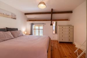 a bedroom with a white bed and a dresser at Domaine de Lestroué - Île d'arz in La Vraie-Croix +15 photos