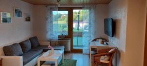 a living room with a couch and a window at Ferienunterkünfte Schüle in Leibertingen
