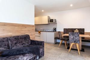 a living room with a couch and a table at Aster Moments Apt Moritz in San Genesio Atesino +21 photos