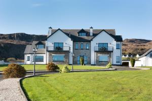 a large house with a green lawn at Ocean Breeze Apt 3 in Dunfanaghy