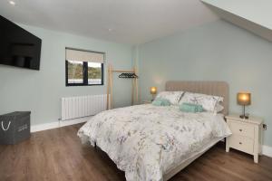 a bedroom with a large bed and a television at Ocean Breeze Apt 3 in Dunfanaghy