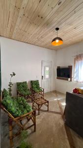a living room with two chairs and a tv at Casa natureza Paraty II in Paraty