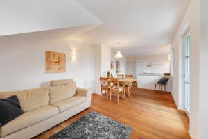 a living room with a couch and a dining room at Apartment Weingut Zail in Appiano sulla Strada del Vino