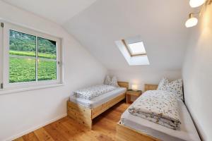 a bedroom with two beds and a window at Apartment Weingut Zail in Appiano sulla Strada del Vino