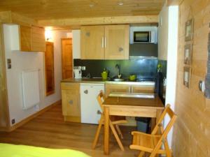 a kitchen with a wooden table and a kitchen with a sink at Chambres d'hôtes le génépi in Valdeblore