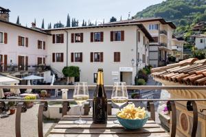 a bottle of wine and two glasses on a table at Ciarii Holiday Homes in Tremosine Sul Garda