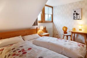 a bedroom with a bed and a desk and a table at Ringlihof in Horben