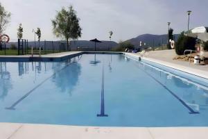 a large swimming pool with blue water at Un duplex con encanto in Jaca