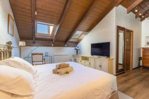 a bedroom with a large white bed with a teddy bear on it at Un duplex con encanto in Jaca +18 photos