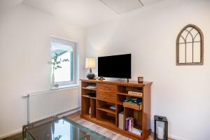 a living room with a television on a wooden entertainment center at Ferienwohnung Maxim in Saarburg