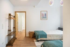 a bedroom with white walls and a bed and a staircase at Ferienwohnung Maxim in Saarburg