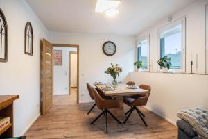 a dining room with a table and chairs and a clock on the wall at Ferienwohnung Maxim in Saarburg +14 photos