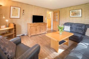 a living room with a couch and a television at Ferienwohnung Krempermoor 1 in Krempermoor