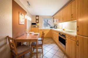 a kitchen with wooden cabinets and a table and chairs at Ferienwohnung Krempermoor 1 in Krempermoor