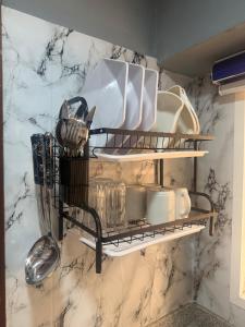 a kitchen shelf with dishes and utensils on it at Max Horizon in Ikeja